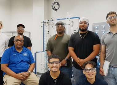 PTech students pose in front of the distillation unit