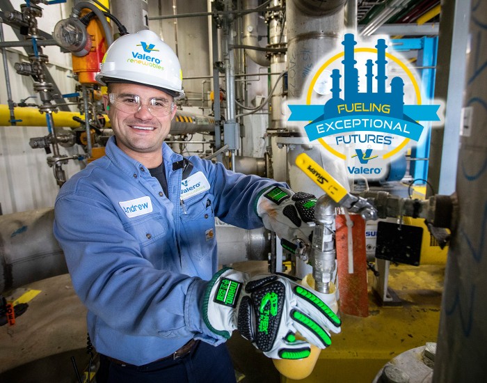 Operator in hard hat smiling while working in plant