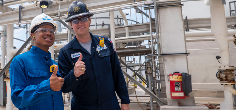 Summit participant with Valero employee giving thumbs up while at the refinery.